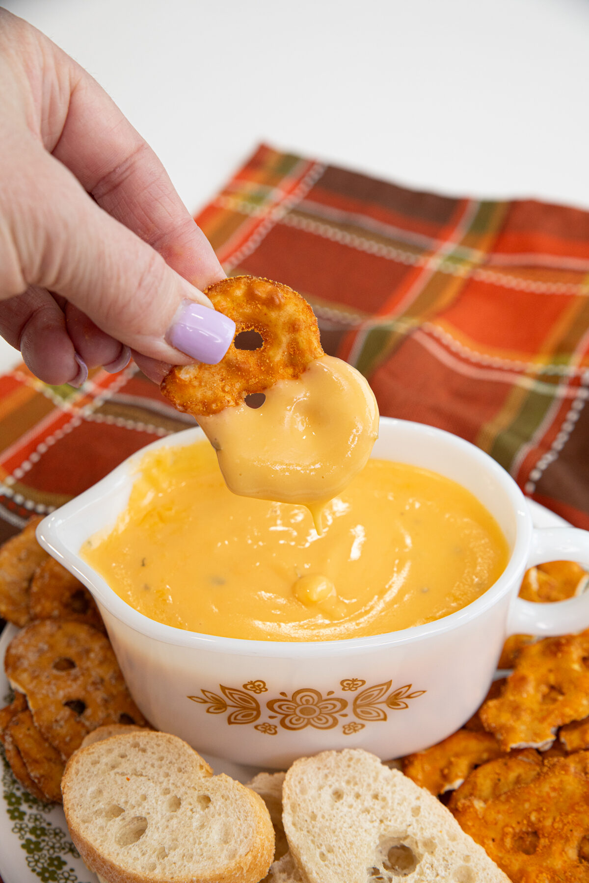 dipping pretzel chips in beer cheese sauce